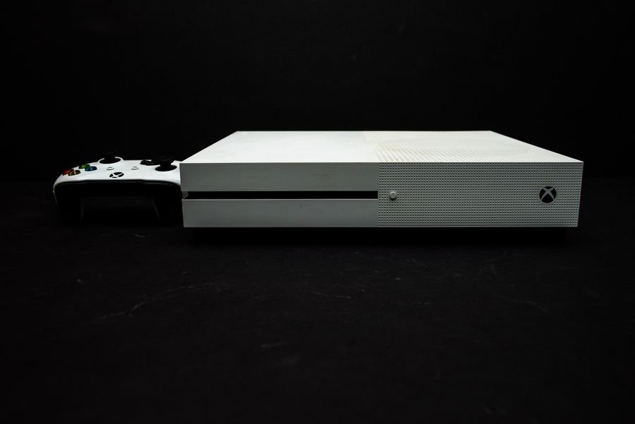 Sobrevivir al colapso: La guía definitiva para dominar los mundos devastados y las hordas de zombies en tu consola Consola de videojuegos blanca con mando negro